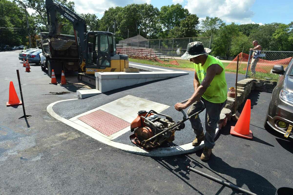 Workers with Deering Construction put the final touches on the newly repaved and enlarged parking area at the Norwalk Senior Center and the Norwalk Early Childhood Center on Allen Road.