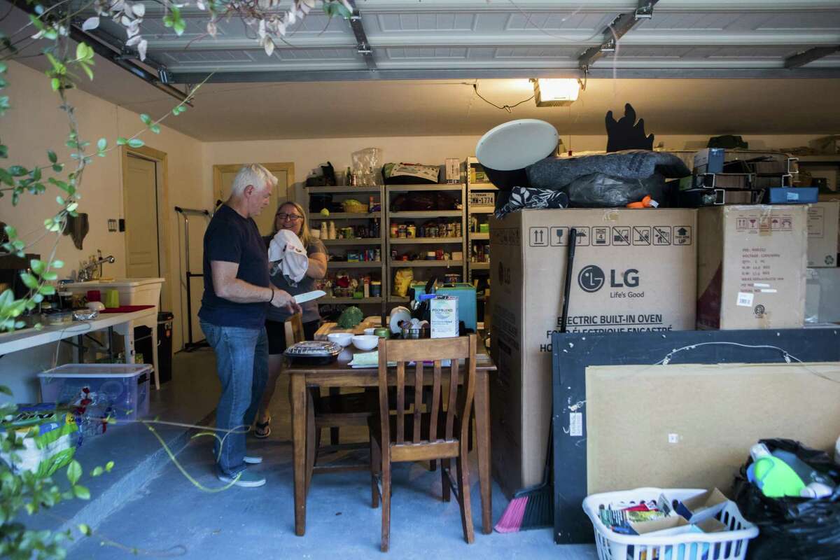 Donnie Blair, 53, and her husband Rodney Blair, 57, prepare dinner in their garage, Monday, Aug. 27, 2018, in Houston, because their home is still not repaired from the flood during the aftermath of Hurricane Harvey.