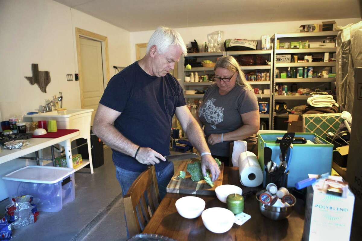 Donnie Blair, 53, and her husband Rodney Blair, 57, prepare dinner in their garage, Monday, Aug. 27, 2018, in Houston, because their home is still not repaired from the flood during the aftermath of Hurricane Harvey.