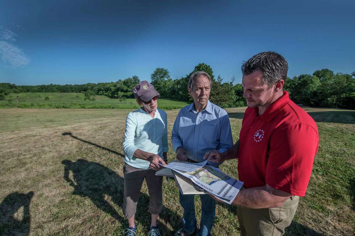 Birchwood Homeowner Association members Lynn MacGowan, left Bob Lansing, center and Adam Brunner, stand by a large field that is the proposed site of an Amazon distribution center Thursday June 21, 2018 in Schodack, N.Y. (Skip Dickstein/Times Union)