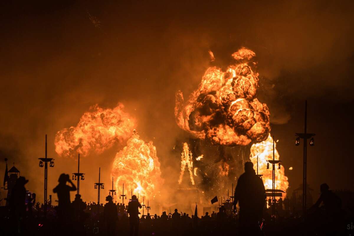 Participants watch the Burning of the Man which marks the end of Burning Man 2018, the largest outdoor arts festival in North America, in the Black Rock Desert of Gerlach, Nevada. ("Sidney Erthal works with the Burning Man Project as an archivist, photographer, and translator.")