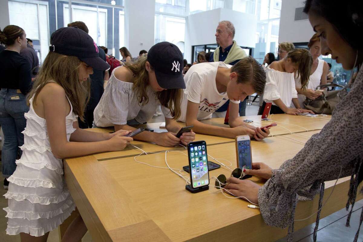 In this Aug. 2, 2018, file photo customers browse in an Apple store in New York. Stamford-based Charter Communications has rolled out its Spectrum Mobile platform, which is compatible with smartphones including iPhones.