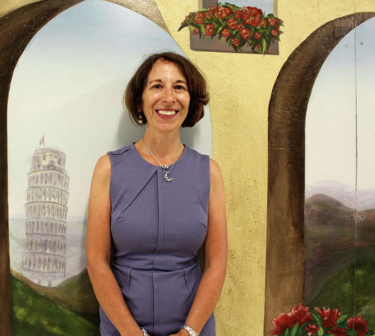 Staples High School Italian teacher Enia Noonan, in front of a mural at the high school, has been named 2018 Westport teacher of the year.