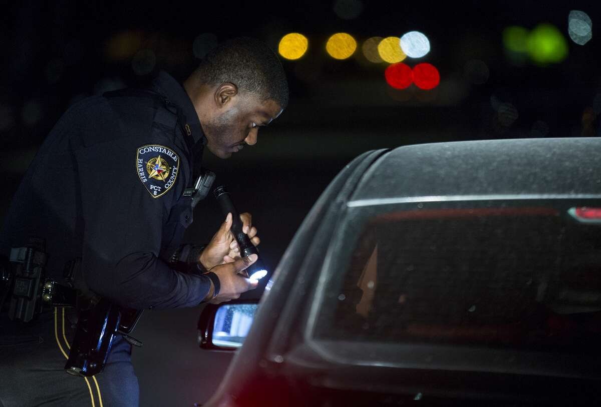 Harris County Precinct 8 deputy constable Jonathan Toliver talks to a motorist during a traffic stop on the Gulf Freeway Service Road.