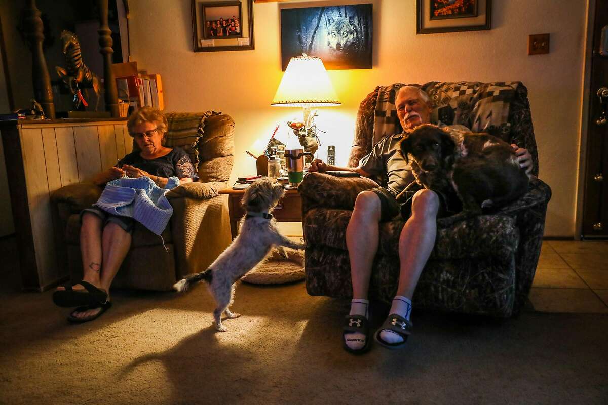 Ted Hickman (right) and wife Linda Hickman relax with their dogs Toto (center) and Lady (right) at their home in Dixon, California, on Monday, Aug. 20, 2018.