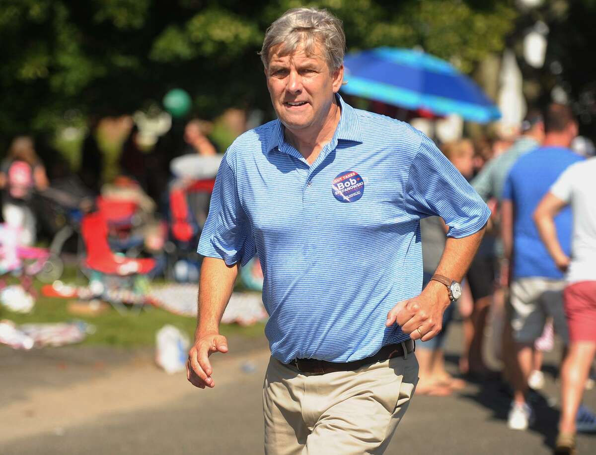 Republican candidate for governor Bob Stefanowski runs back and forth shaking hands during the Newtown Labor Day Parade on Main Street in Newtown last Monday.