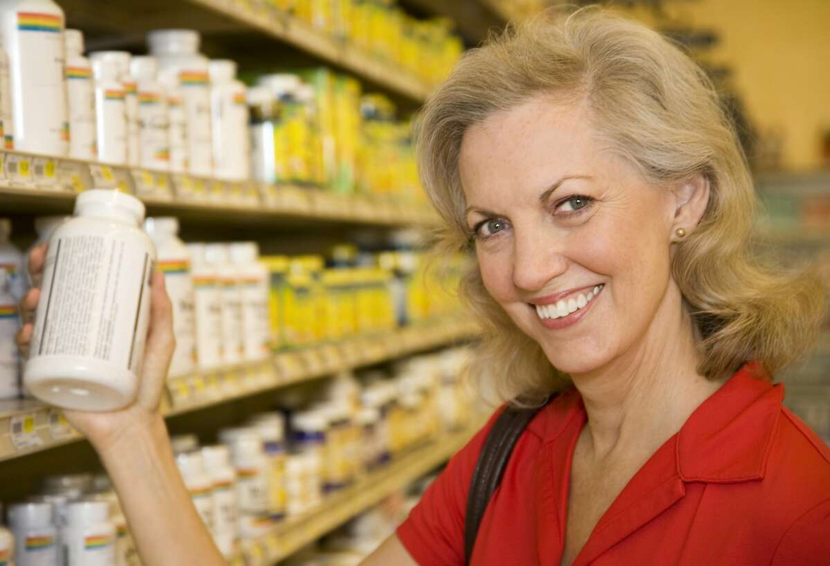 Health Conscious Shopper Checking Vitamin Bottle at the Store
