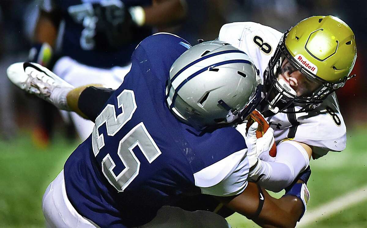 Hand’s Ian Butler is tackled by Hillhouse defensive back Treronn Bryant during their game on Friday in New Haven.