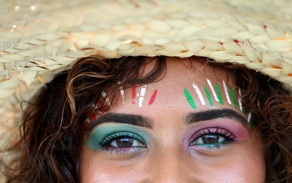 White, green, and red paint color Viviana Gonzalez's forehead in support of the Mexico men's national team before they face Uruguay at NRG Stadium Friday, Sept. 7, 2018, in Houston.