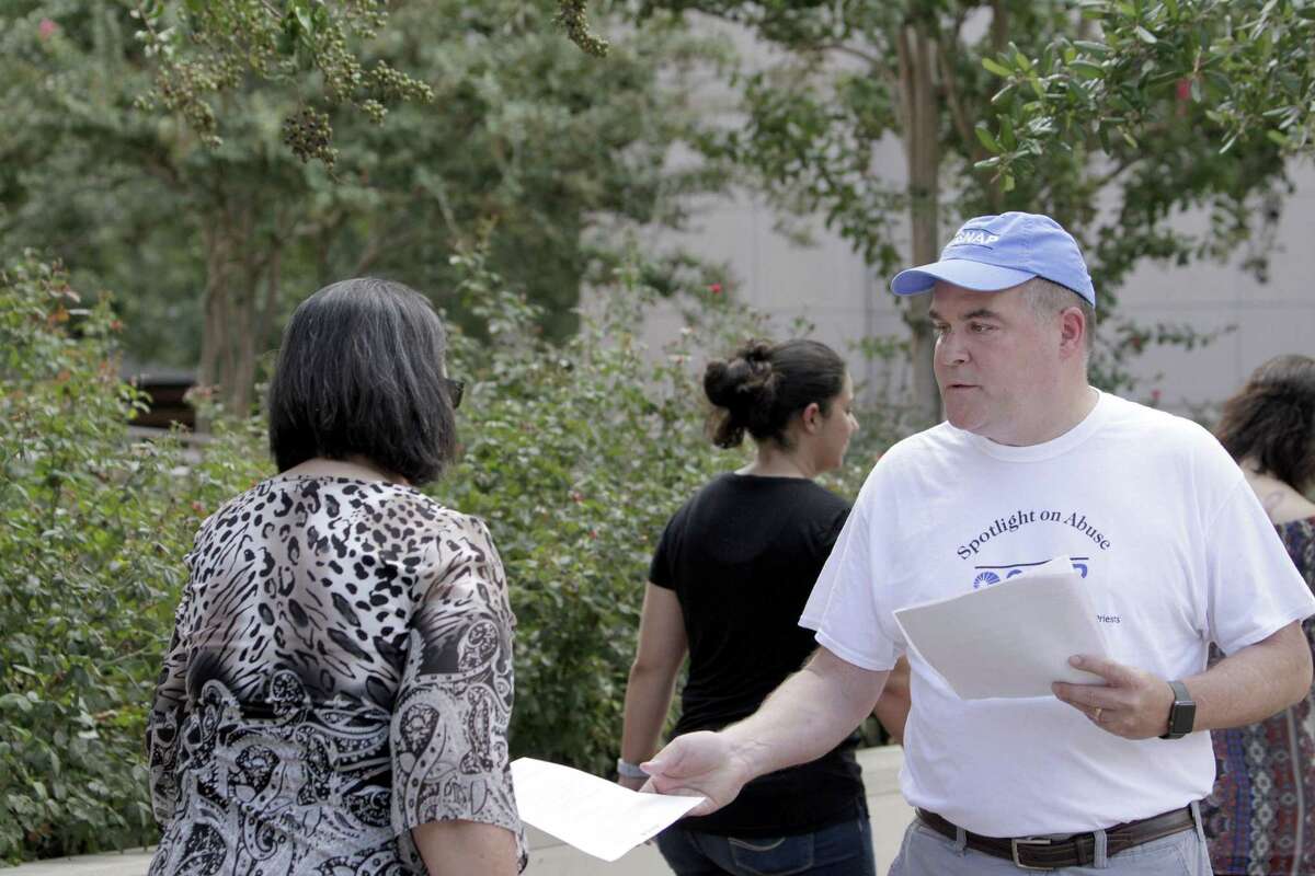 Michael Norris, leader of the Houston chapter of SNAP, passes out flyers on the sidewalk outside the Co-Cathedral of the Sacred Heart Sunday morning to advocate for victims of sexual abuse by clergy members of the Catholic church.