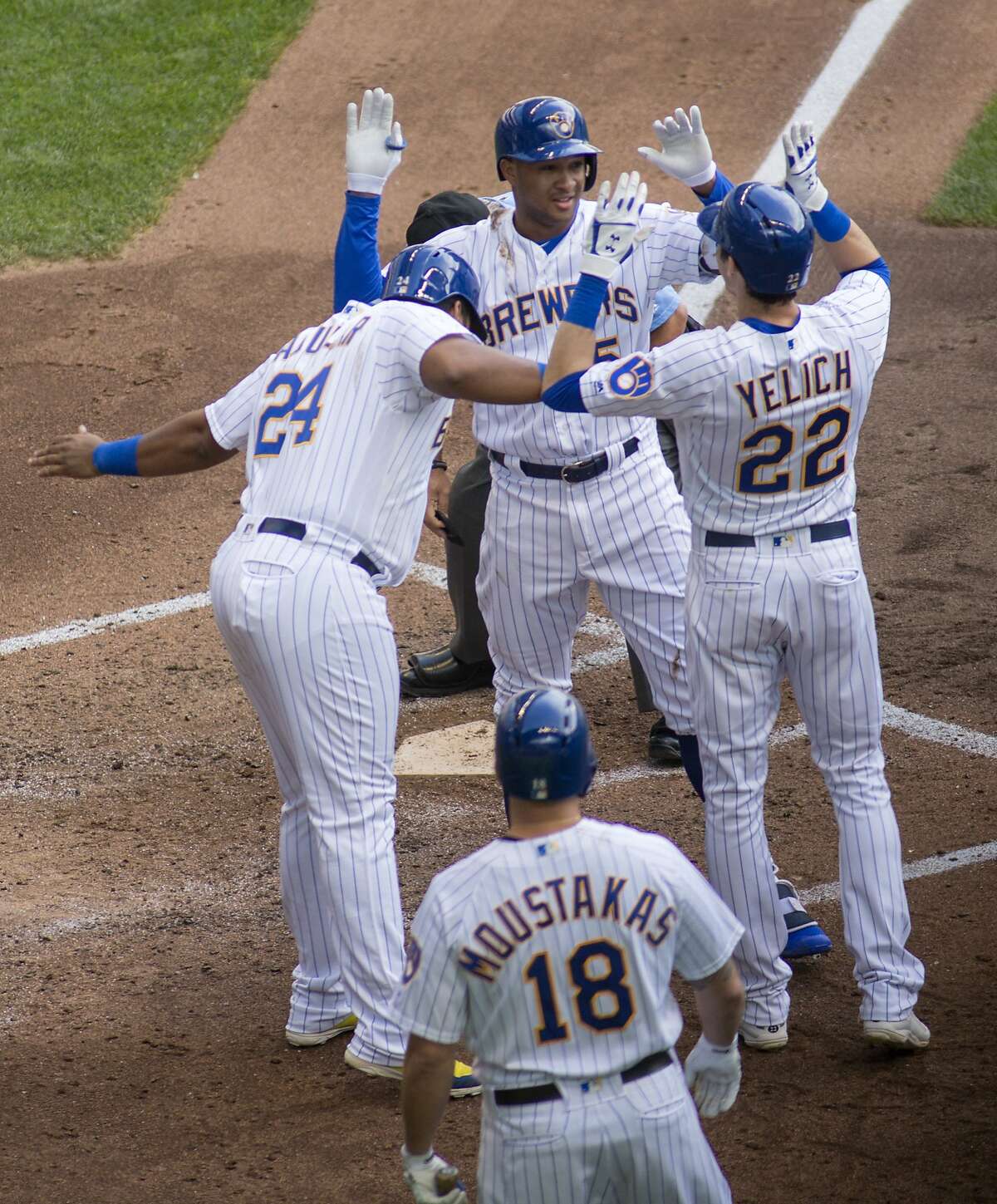 Milwaukee Brewers' Jonathan Schoop, top center, is congratulated by teammates after hitting a grand slam against the San Francisco Giants during the sixth inning of an baseball game Sunday, Sept. 9, 2018, in Milwaukee. (AP Photo/Darren Hauck)