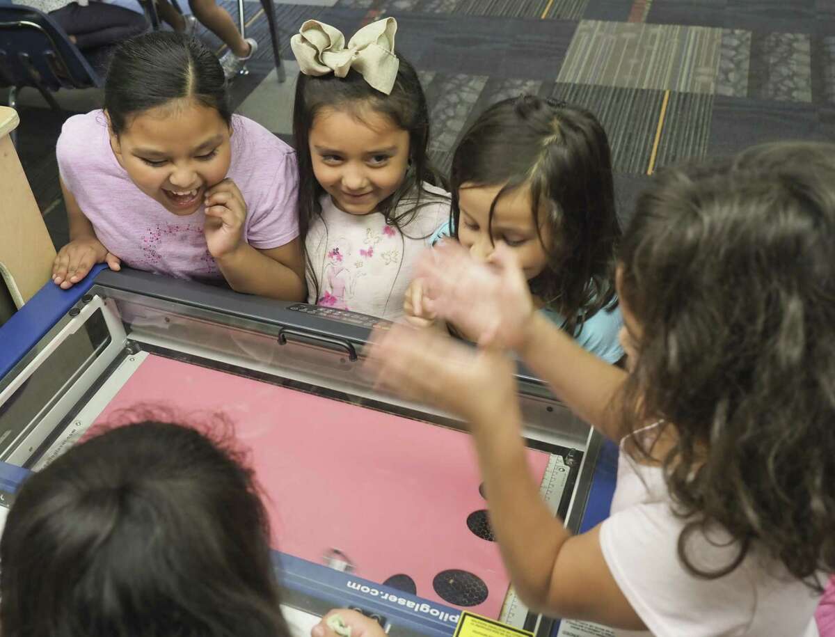 Students watch as the laser etcher and cutter makes nametags on at the Boys & Girls Club on July 31, 2018. The Odessa College mobile Fab Lab was in town to show computer techniques as part of bringing STEM curriculum to students.