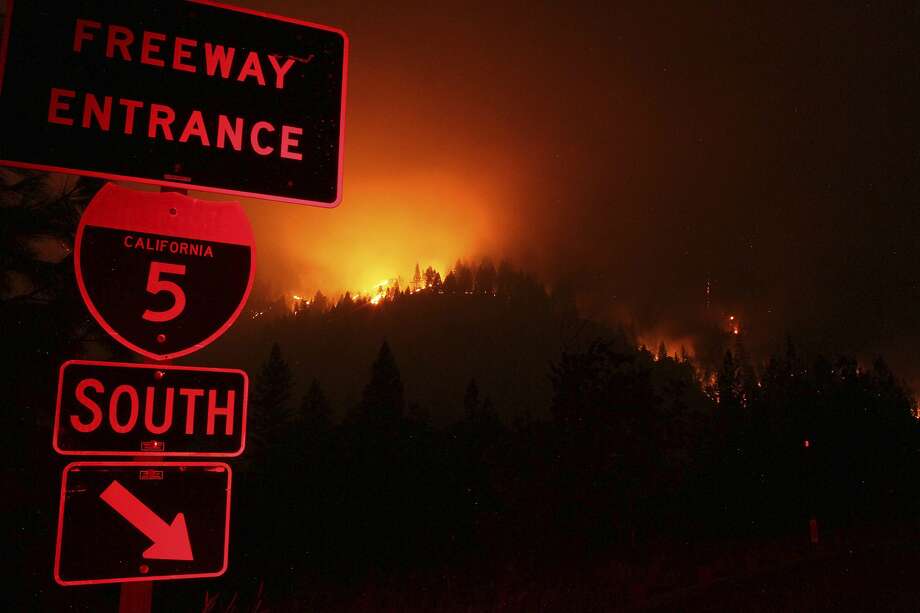 In this Friday, Sept. 7, 2018 photo, wildfires continued to burn on the ridge line east of I-5 just south of Gibson Rd., exit near Shasta-Trinity National Forest, Calif. A roaring wildfire that has shut down a stretch of a major interstate in a rural area near the California-Oregon border has nearly doubled in size. The blaze in California's Shasta-Trinity National Forest is burning out of control and crews Saturday, Sept. 8, are scrambling to prevent it from reaching mountain communities to the north. (Hung T. Vu/The Record Searchlight via AP) Photo: Hung T. Vu / Associated Press