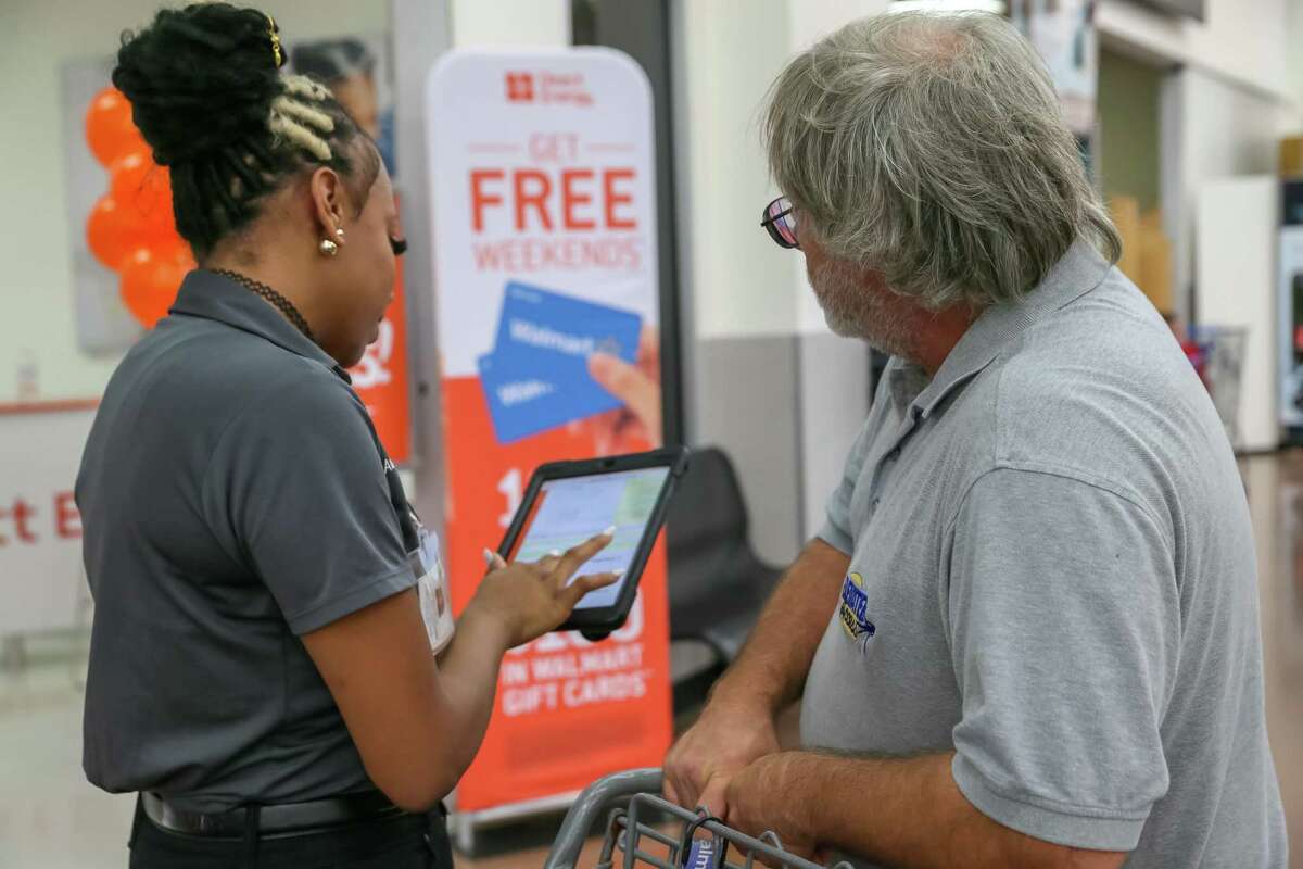 August 16, 2018: Direct Energy Team Leader Laporsha Woody explains potential savings to local shopper and Santa Fe resident Scott Mahon at the Walmart Supercenter in League City, Texas. (Leslie Plaza Johnson/For the Chronicle)