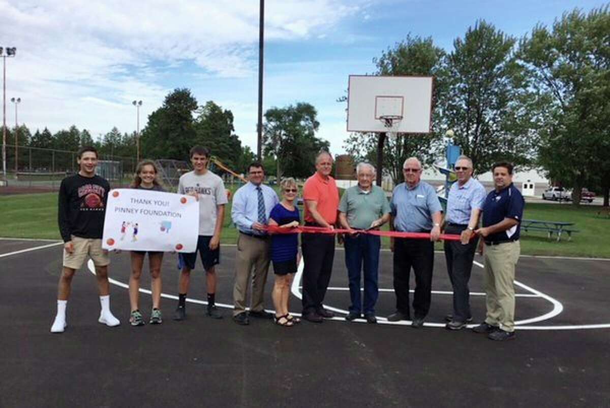 Representatives from the Pinney Foundation and Cass City's Village Council, along with student basketball players, recently held a ribbon cutting ceremony for the renovated basketball courts. Two grants from the Pinney Foundation totaling $19,900 helped the village pay for the court's resurfacing work. (Submitted Photo)