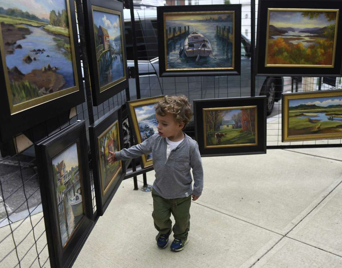 Riverside's Lucas McConnell, 2, looks at paintings from Daisy de Puthod on display at the Annual Sidewalk Art Show and Sale, sponsored by the Art Society of Old Greenwich, along Sound Beach Avenue in Old Greenwich, Conn. Sunday, Sept. 9, 2018. The two-day show and sale featured work by dozens of local artists of all mediums. There was also a Sidewalk Art Show for Young Artists, where children and teens exhibited their work, as well as a live performance by jazz pianist Lucas Gazianis, a member of the Jazz at Lincoln Center Youth Orchestra.