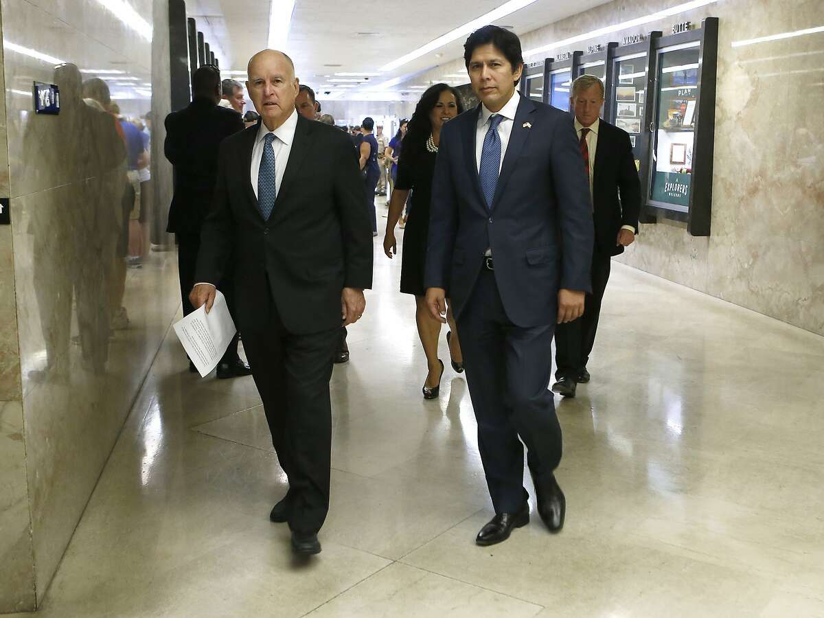 Calif., Gov. Jerry Brown, left, walks to a news conference where he signed SB100 an environmental bill authored by state Sen. Kevin de Leon, D-Los Angeles, right, Monday, Sept. 10, 2018, in Sacramento, Calif. SB100 sets a goal of phasing out all fossil fuels from the state's electricity sector by 2045. (AP Photo/Rich Pedroncelli)