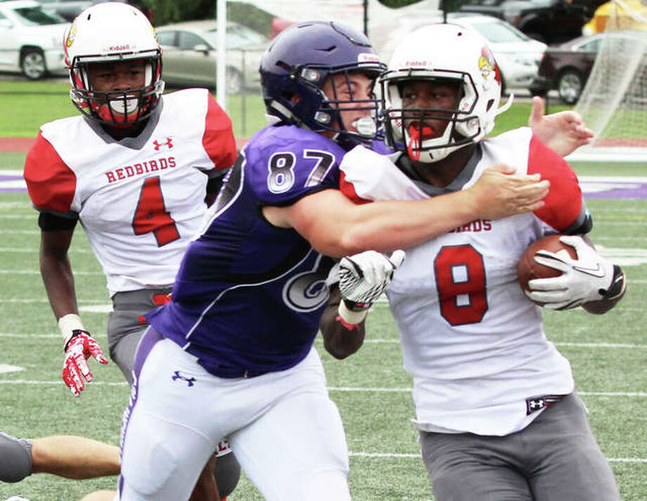 Collinsville’s Drew Doyle takes down Alton’s Terrance Walker (8) after a big gain in the Redbirds’ 35-6 Southwestern Conference football victory over the Kahoks on Saturday afternoon in Collinsville. Alton’s Ahmad Sanders (4) trails the play. Photo: Greg Shashack | The Telegraph