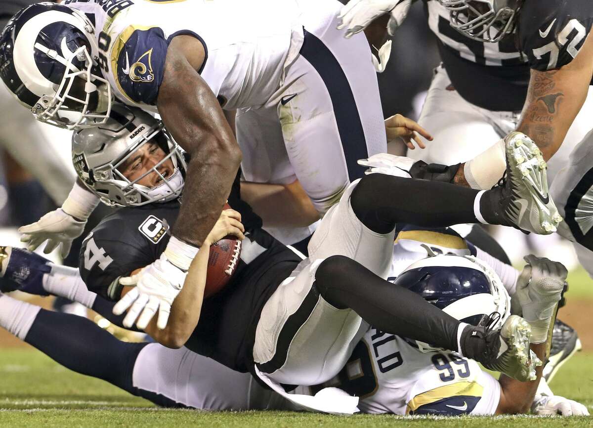 Los Angeles Rams' Aaron Donald (99) commits a personal foul while sacking Oakland Raiders' Derek Carr in 1st quarter during NFL game at Oakland Coliseum in Oakland, Calif. on Monday, September 10, 2018.