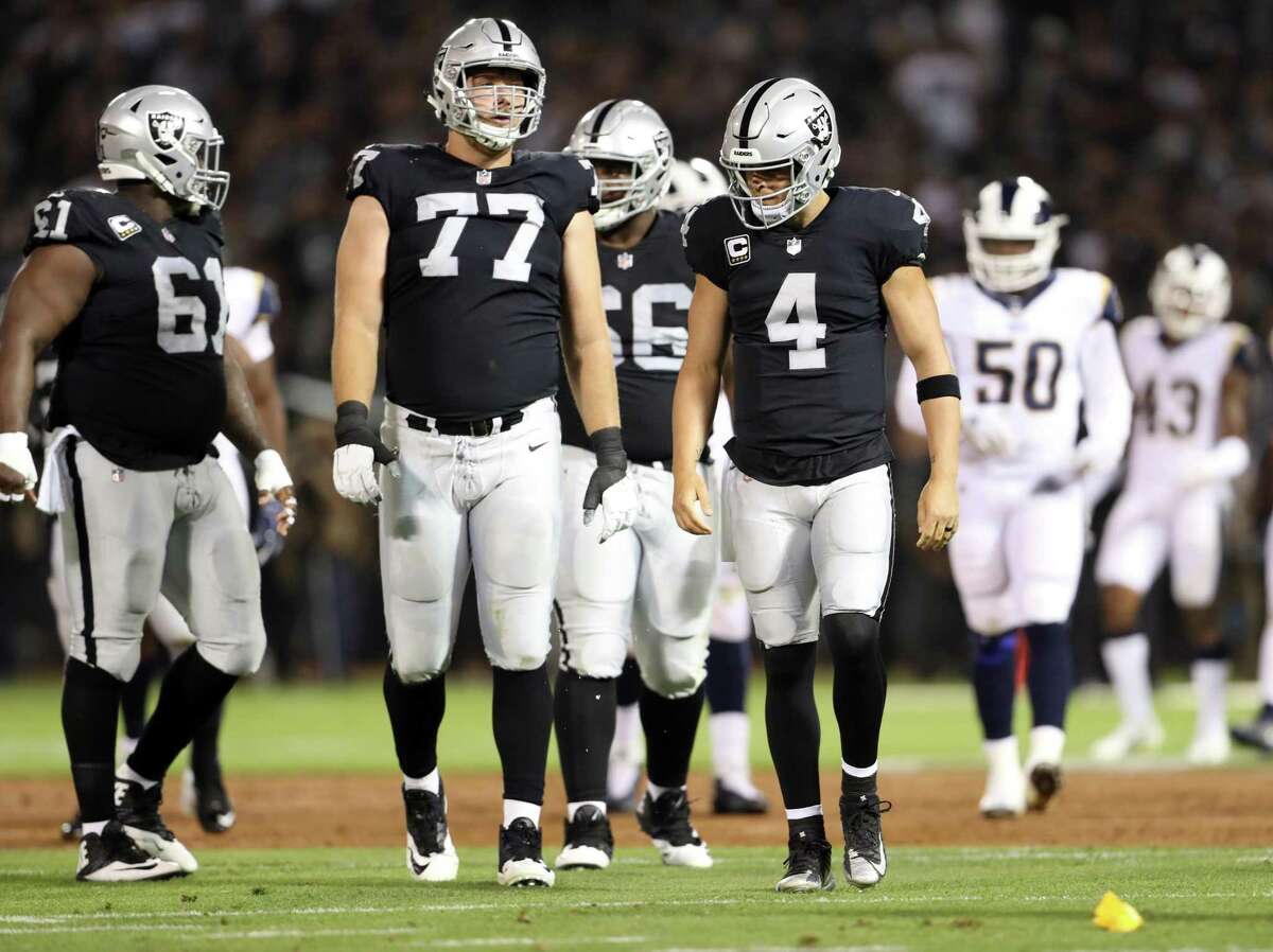 Oakland’s Derek Carr (4) and Kolton Miller (77) react after the rookie Miller was penalized for holding in the first quarter.