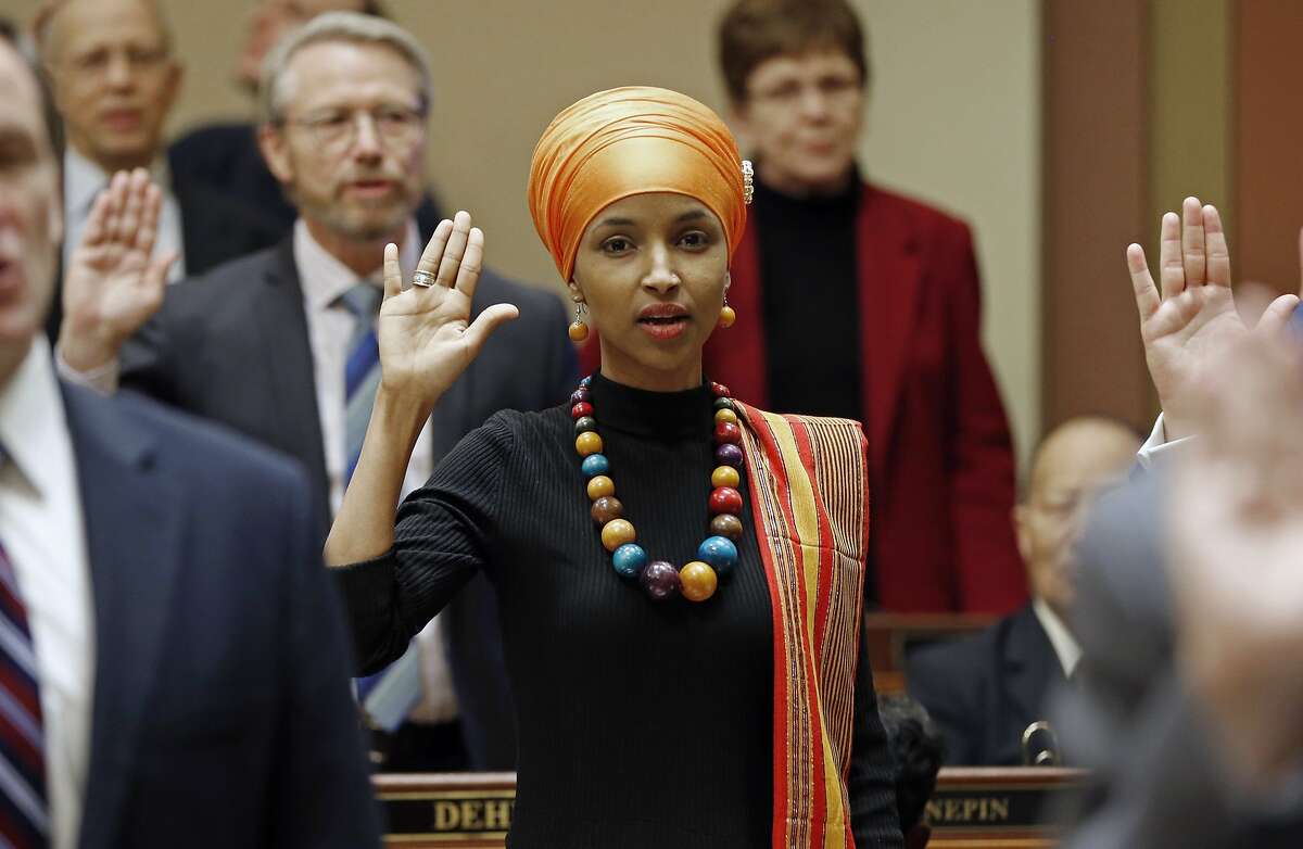 FILE - In this Tuesday, Jan. 3, 2017 file photo, State Rep. Ilhan Omar takes the oath of office as the 2017 legislature convened in St. Paul, Minn. Omar, a Muslim, is the nation's first Somali-American to be elected to a state legislature. Religion's role in politics and social policies is in the spotlight heading toward the midterm elections, yet relatively few Americans consider it crucial that a candidate be devoutly religious or share their religious beliefs, according to an AP-NORC national poll conducted Aug. 16-20, 2018. (AP Photo/Jim Mone)