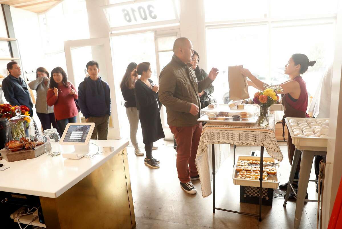 Kate Campesino-Wong hands out an order during Breadbelly's pop-up stand at Andytown Roastery in San Francisco, Calif. on Sunday, September 9, 2018.