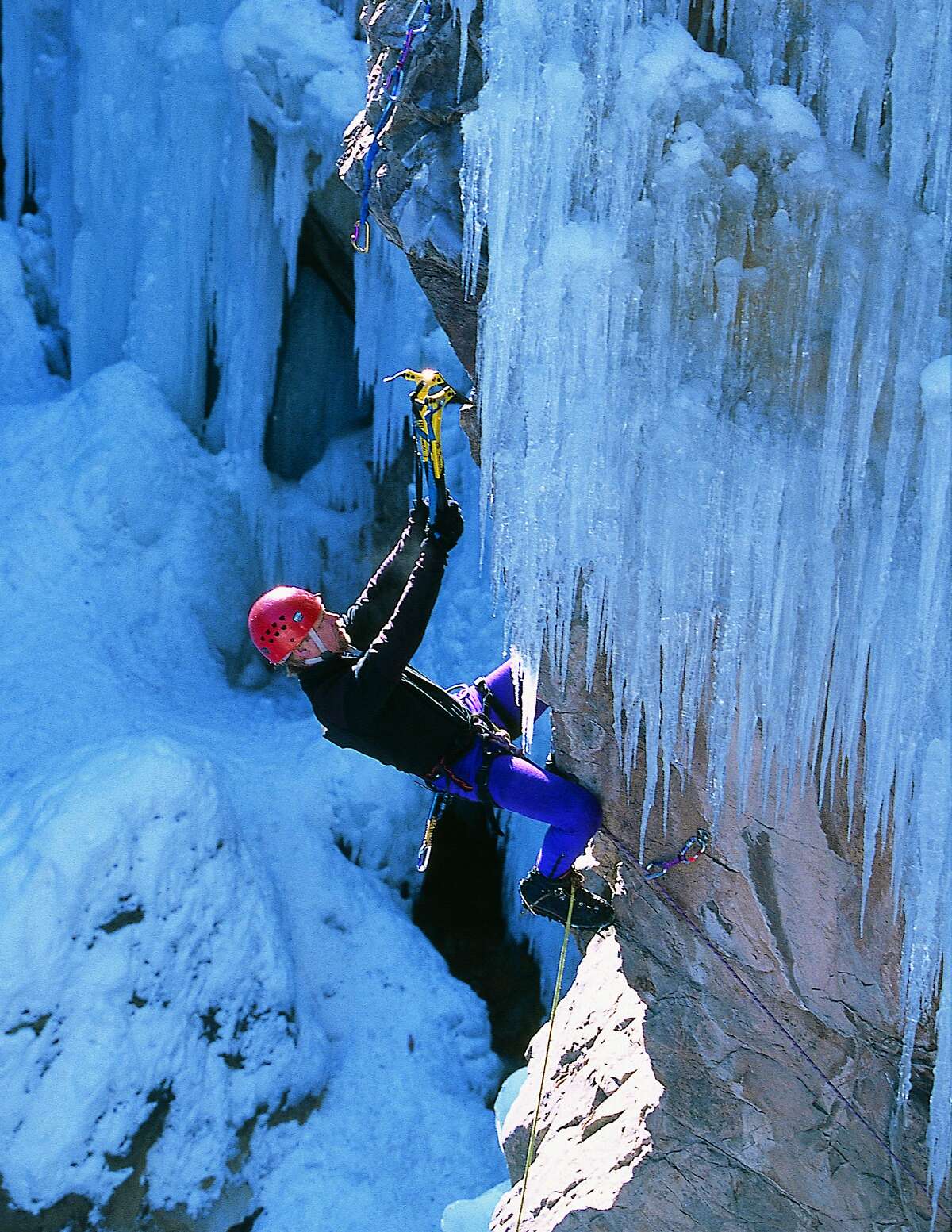 This 1990s photo provided by Adaptable Man LLC and JeffLoweClimber.com shows climber Jeff Lowe tackling an icy wall in Ouray, Colo., on a route he named Dizzy With A Vision. Lowe, an elite climber and inventor of products and techniques, died Friday, Aug. 24, 2018 at a care facility in Fort Collins, Colo. He was 67. (Adaptable Man LLC via AP)