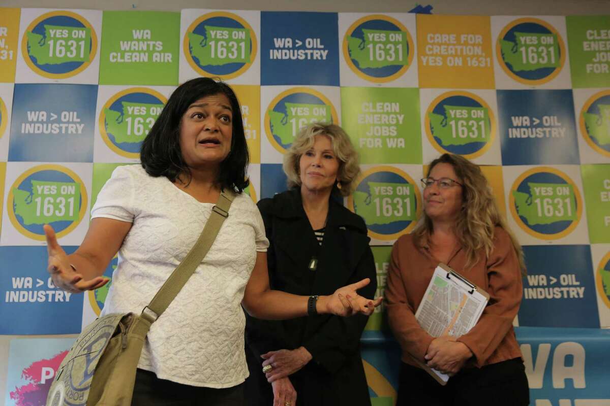 Actress and activist Jane Fonda, center, and volunteer BJ Cummings, right, listen as U.S. Rep. Pramila Jayapal speaks to volunteers during a campaigning event for Initiatives 1639 and 1631, which address gun safety and clean energy respectively, in the University District, Tuesday, September 11, 2018, before going out canvassing in the area.