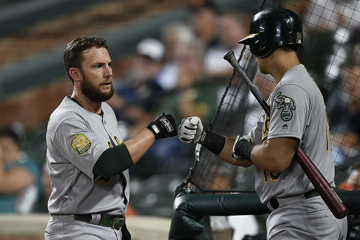 Oakland Athletics' Jed Lowrie, left, is congratulated by Chad Pinder after scoring against the Baltimore Orioles in the third inning of a baseball game, Tuesday, Sept. 11, 2018, in Baltimore. (AP Photo/Gail Burton)