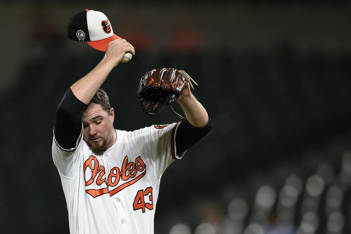 Baltimore Orioles pitcher Mike Wright Jr. wipes his face after the Oakland Athletics score three runs in the third inning of a baseball game, Tuesday, Sept. 11, 2018, in Baltimore. (AP Photo/Gail Burton)