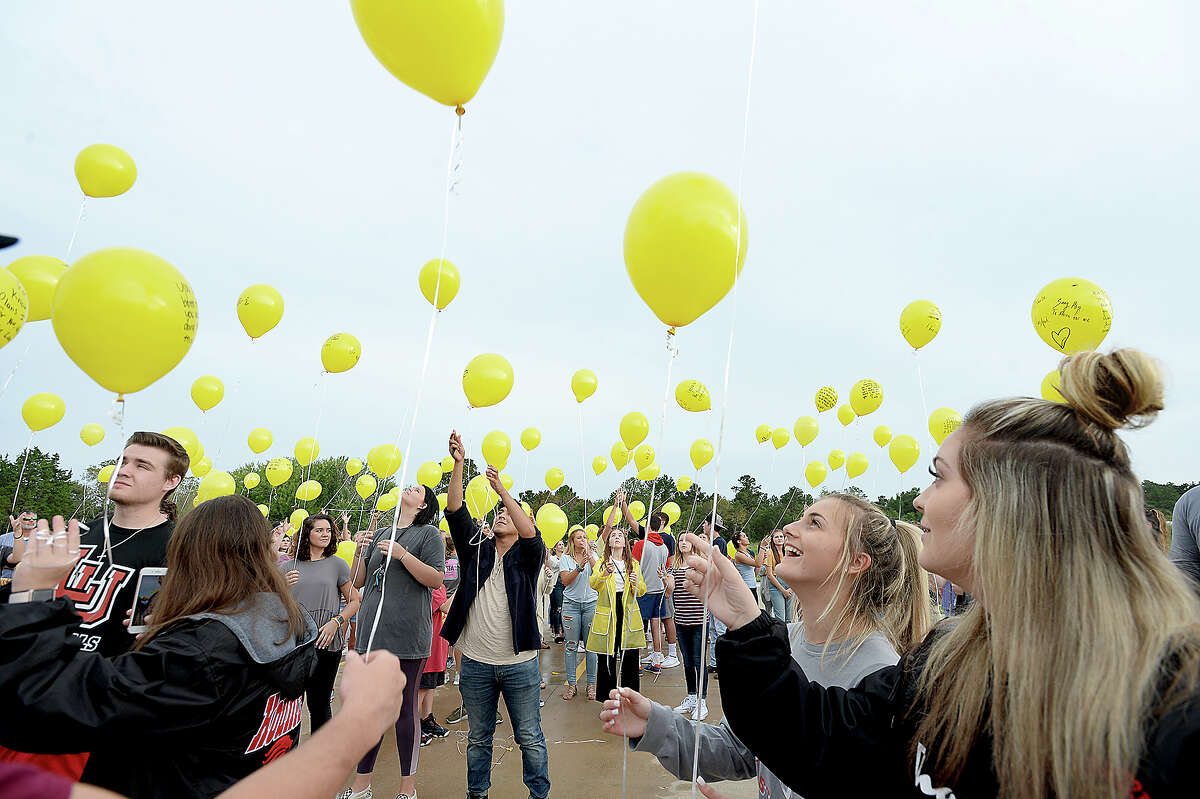 Attendees look skyward as they release their balloons, each bearing messages of remembrance and hope, during a memorial balloon release at Praise Church in honor of the three teens killed in a car accident Sunday in Hardin County. 2018 Hardin-Jefferson graduate Alix Neel, and 2018 West Hardin graduates Garrett Saulters and Caringtin Mosley were remembered by friends, family and members of the community at the vigil. Visitations and funerals for the teens began Wednesday and continue through Friday. Wednesday, September 12, 2018 Kim Brent/The Enterprise