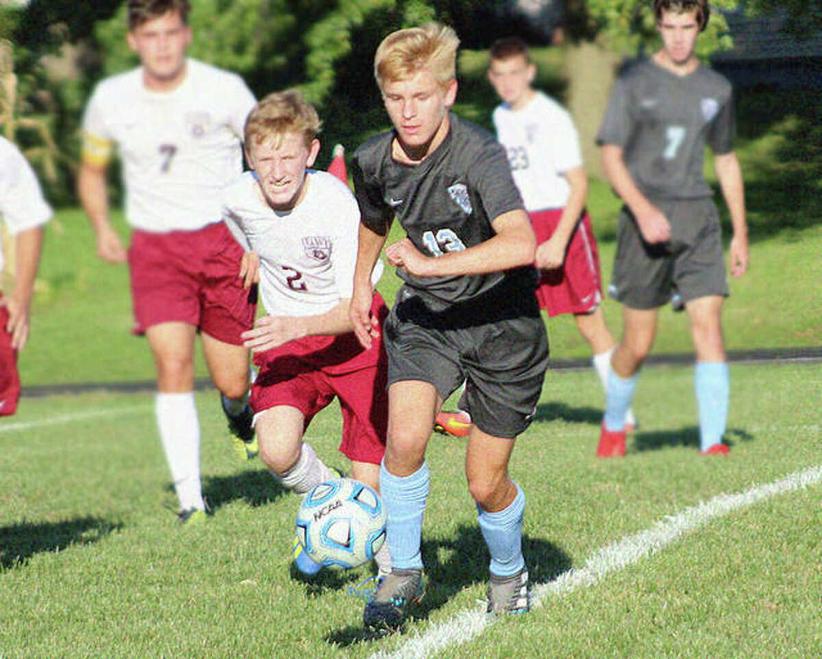 Jersey’s Cody Miller (13) and EA-WR’s Cooper Faust (2) race for the ball Wednesday in Jerseyville. Jersey won 4-2.