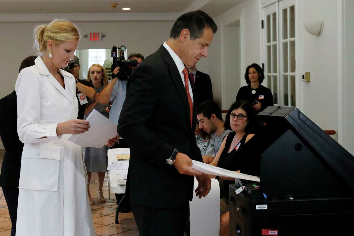 New York Gov. Andrew Cuomo, accompanied by his girlfriend Sandra Lee, puts his primary election ballot in a scanner at the Presbyterian Church of Mount Kisco, in Mt. Kisco, NY, Thursday, Sept. 13, 2018.
