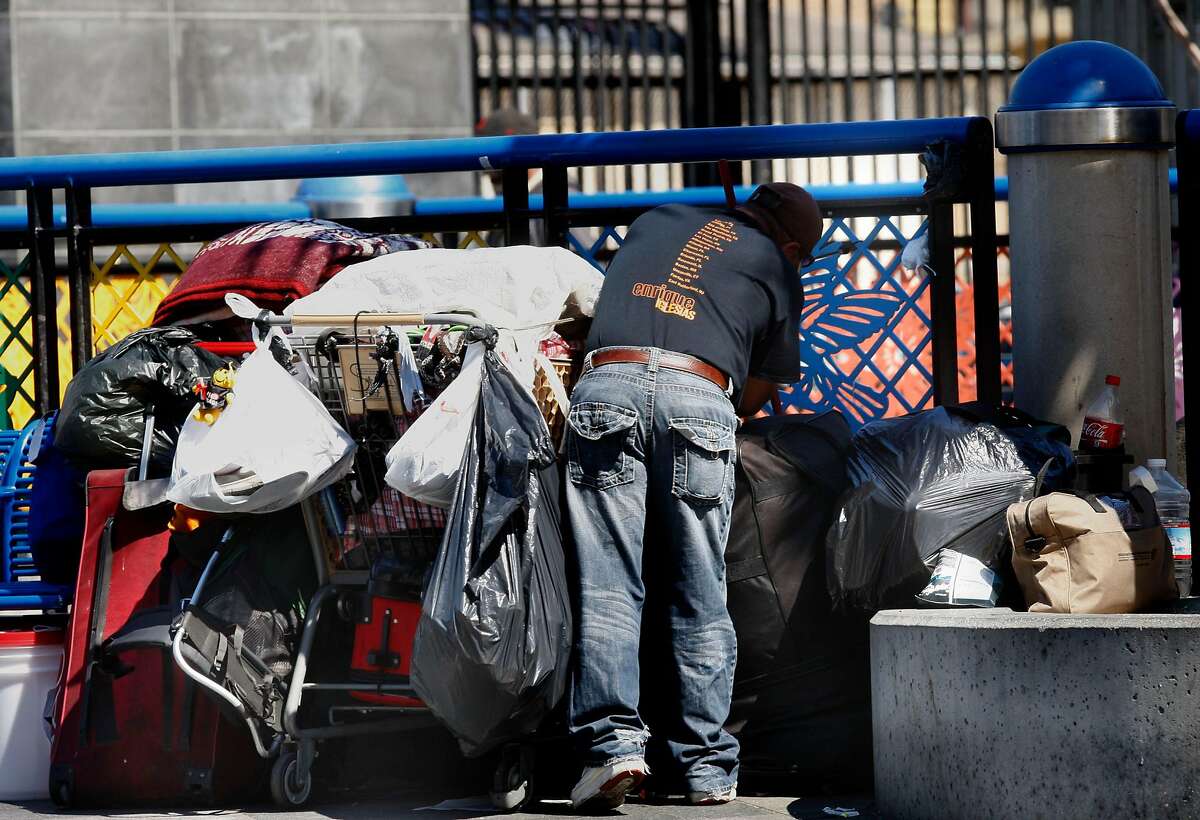 A man going through his belongings on the street level plaza of the Bart station on Mission at 16th streets in San Francisco, Calif., on Wednesday, July 11, 2012.