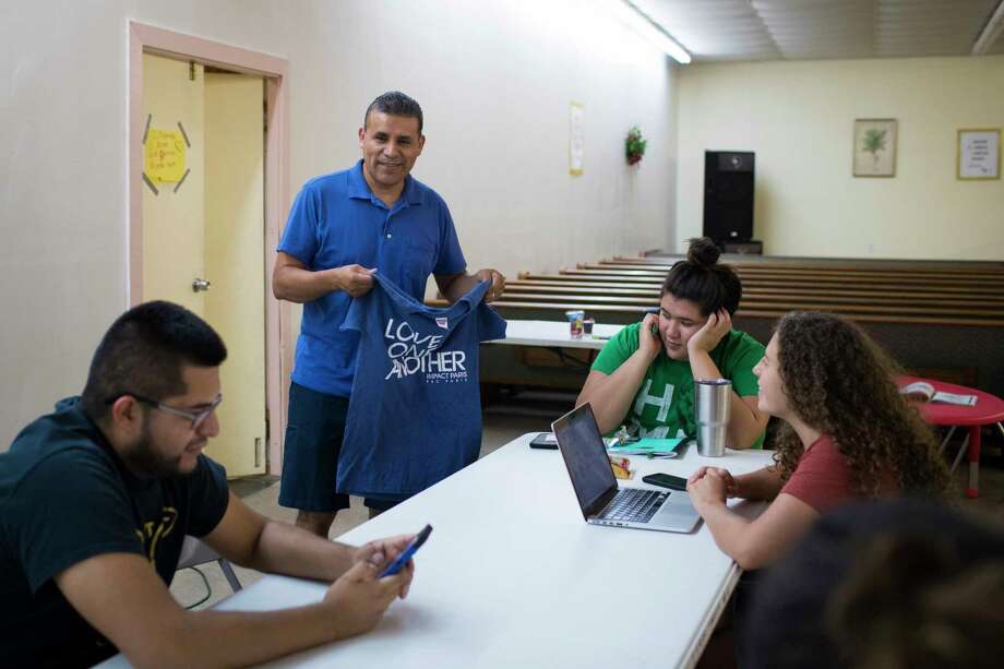 Pastor Beto Prado, who has been helping families affected by the ICE raid, looks at a t-shirt that says "Love One Another" before a planning meeting, Thursday, Sept. 6, 2018, in Paris. Photo: Marie D. De Jesús, Staff Photographer / © 2018 Houston Chronicle