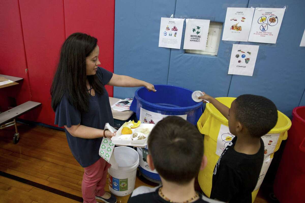 PTO and Green Works member Gena Russo helps young students recycle properly after their lunch inside Northeast Elementary School in Stamford, Conn. on Thursday, Sept. 13, 2018.
