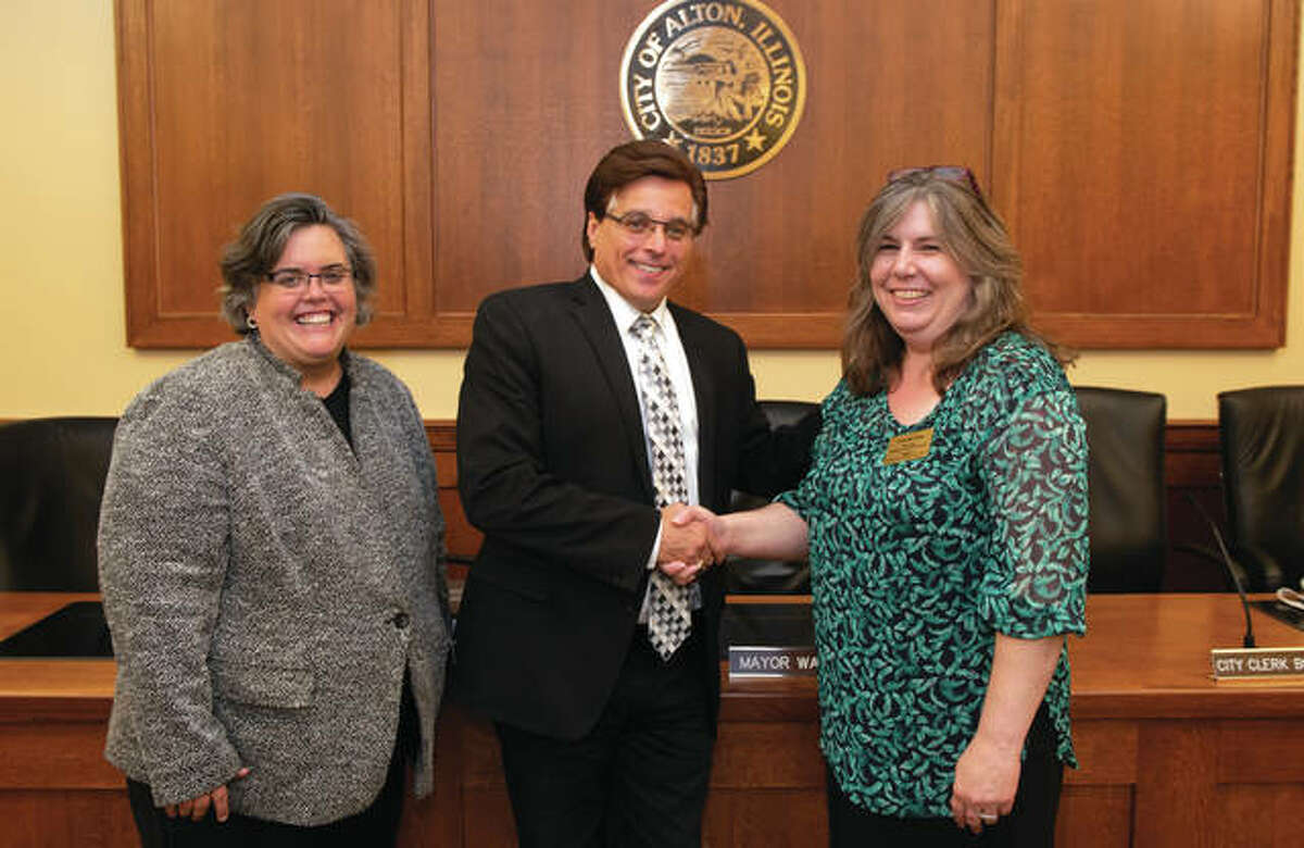 Following a signing agreement with the City of Alton and SIUE, Mayor Brant Walker (center) shakes hands with Connie Frey-Spurlock, PhD, associate professor in the Department of Sociology and SIUE Successful Communities Collaborative (SSCC) faculty director. Denise Cobb, PhD, provost and vice chancellor for academic affairs (left) participated in the ceremony.