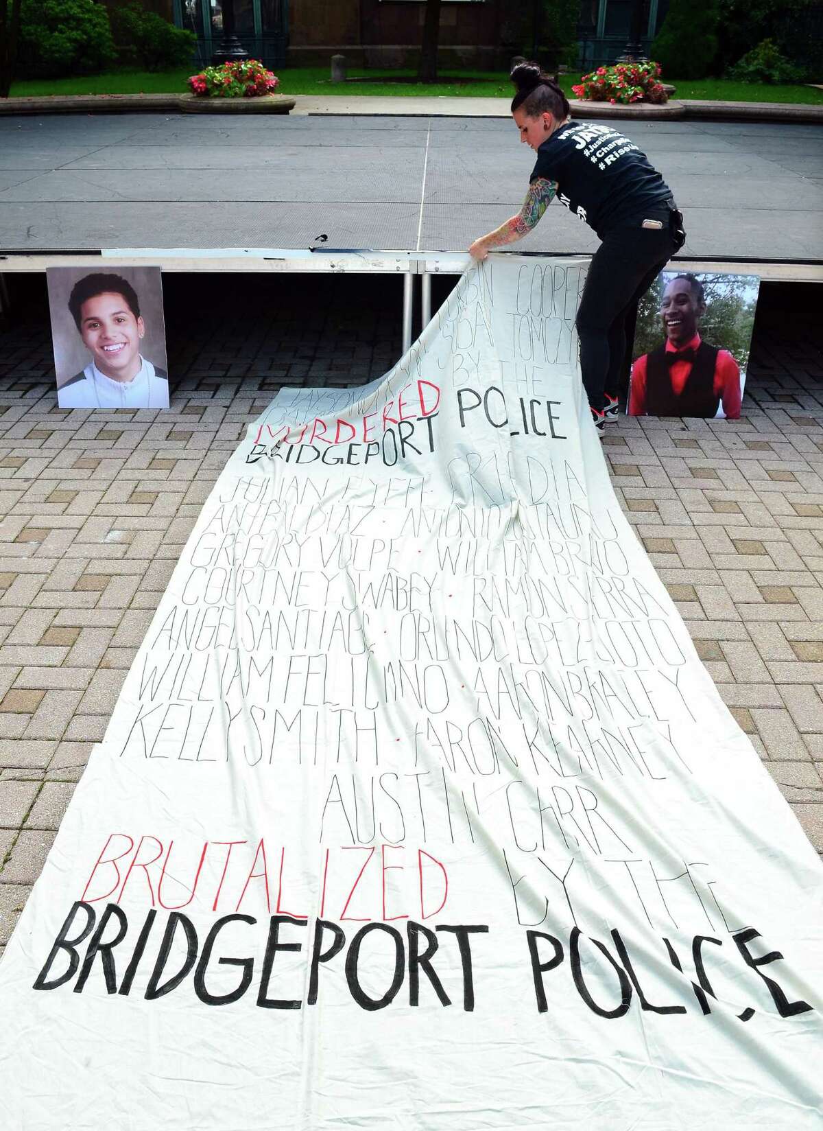 Sarah Pimento, with the Justice for Jayson Coalition, works on securing a banner made for a rally organized by the coallition and Bridgeport Generation Now at McLevy Green in downtown Bridgeport, Conn., on Friday Sept. 14, 2018. Participants remembered Negron, who was killed in a shooting by the Bridgeport Police last May, as well as several others who attendees said were murdered or brutalized by police.