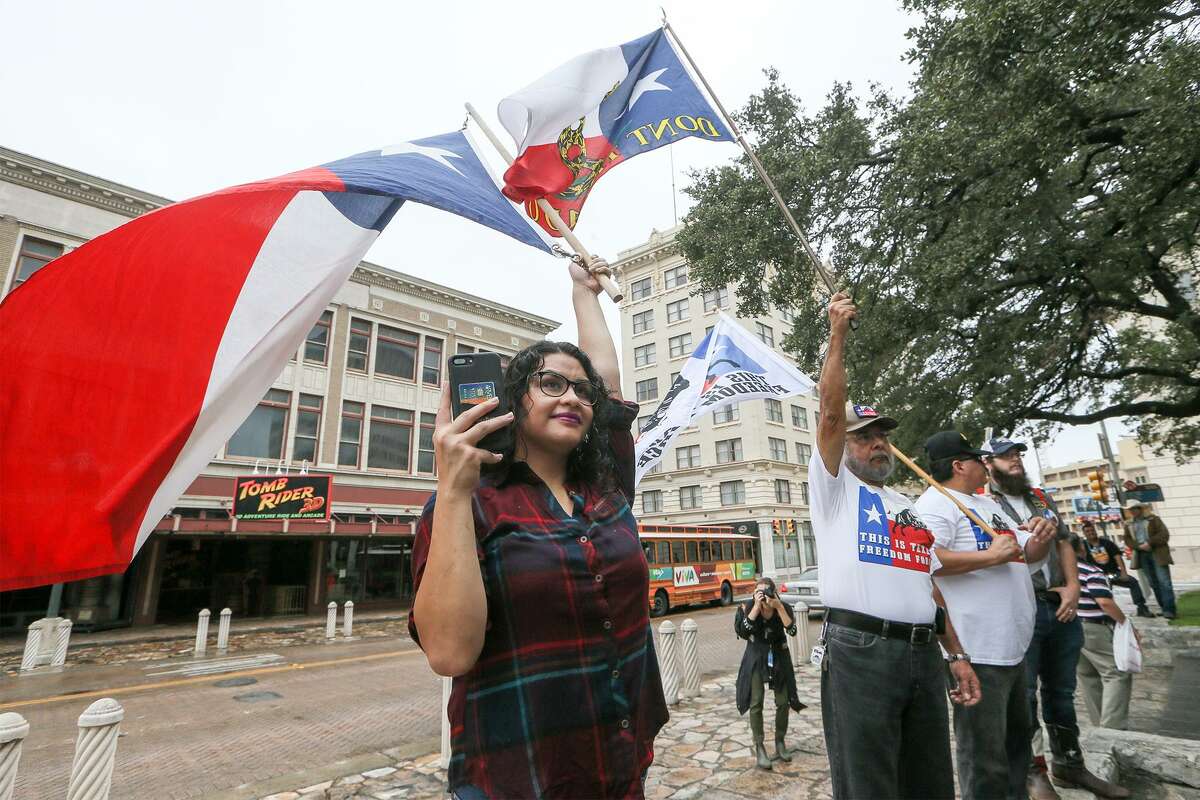 Karina Gurrola, from left, Lupe Rivera, Ramon Garza and Paul Gescheidle hold flags as state Rep. Kyle Biedermann, R-Fredericksburg, holds a news conference Sept. 14 at the Cenotaph to oppose the proposed Alamo master plan and to urge officials to include the Texas Legislature in the negotiations going forward.