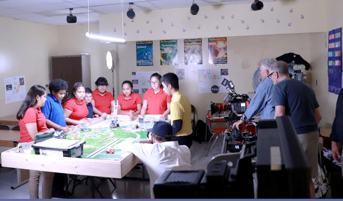 Four Cigarroa Middle School students are shown with Tony Arce, AEP manager, during filming.