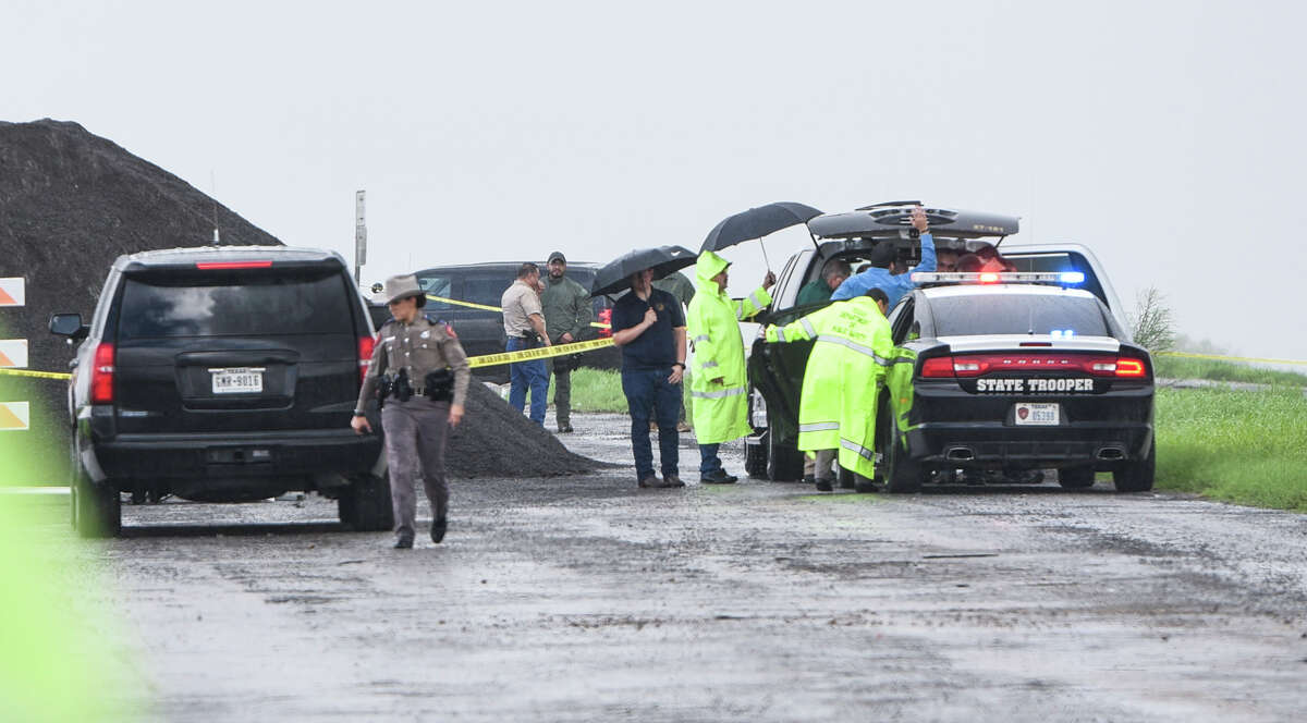 Law enforcement investigates the scene where a fourth body was found was found Saturday, Sept. 15, 2018, near mile marker 14 of Interstate 35. A Border Patrol agent has been detained in connection with the slaying of four prostitutes.