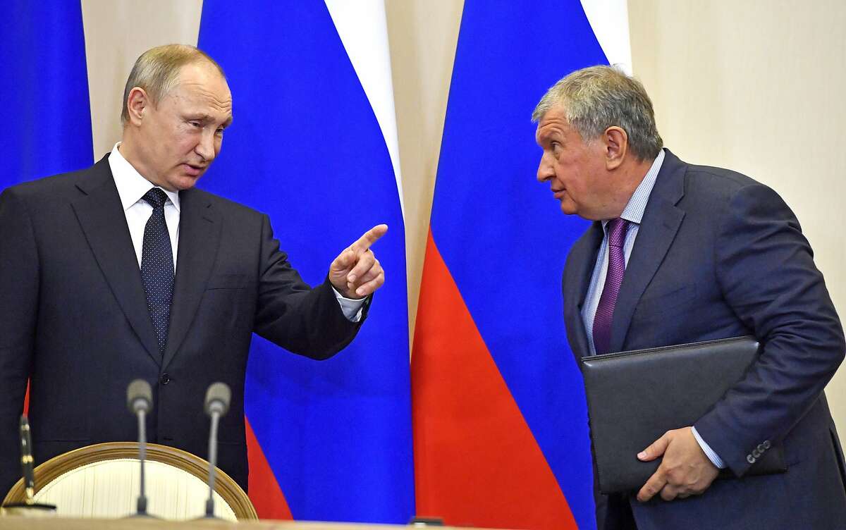 FILE In this file photo taken on Wednesday, May 12, 2018, Russian President Vladimir Putin, left, speaks with Igor Sechin, CEO of Russian oil giant Rosneft, at a joint news conference with Italian Prime Minister Paolo Gentiloni at the Bocharov Ruchei state residence in Russian Black Sea resort of Sochi, Russia. 