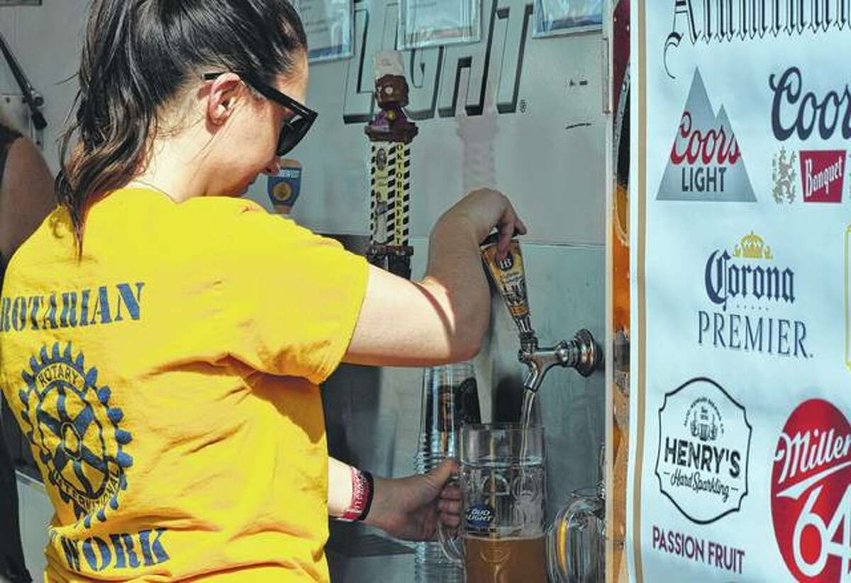 Jacksonville Rotarian Jenna Tucker pours a beer Saturday at the Rotary Club’s Oktoberfest.