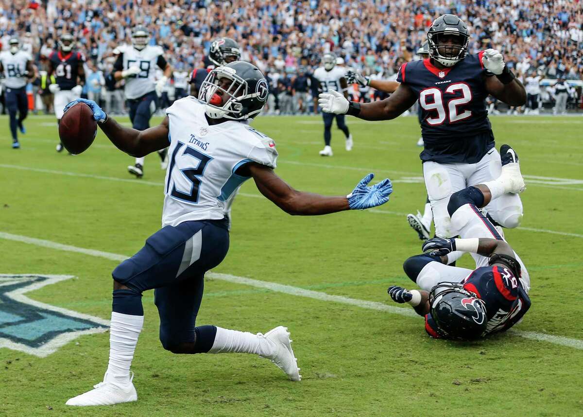 Tennessee Titans wide receiver Taywan Taylor (13) runs past Houston Texans linebacker Benardrick McKinney (55) and defensive tackle Brandon Dunn (92) for an 18-yard touchdown reception during the first quarter of an NFL football game at Nissan Stadium on Sunday, Sept. 16, 2018, in Nashville.