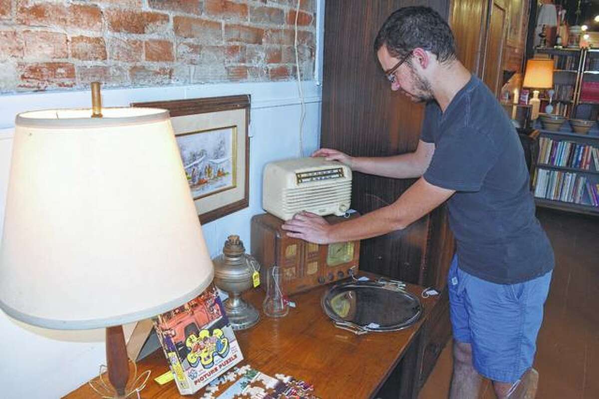 Nick Little of Jacksonville adjusts an old radio in his family’s new antiques store in downtown Jacksonville.