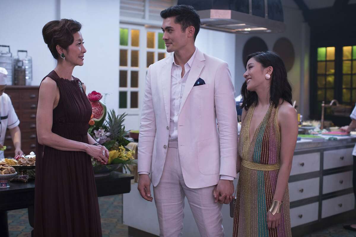This image released by Warner Bros. Entertainment shows Michelle Yeoh, from left, Henry Golding and Constance Wu in a scene from the film "Crazy Rich Asians." When �Crazy Rich Asians� surpassed expectations and grabbed the top spot in its opening weekend, the film also pulled off another surprising feat. It put Asians of a certain age in theater seats. Younger Asian-Americans have been flocking with their parents to see the first movie in 25 years with an all-Asian cast. (Sanja Bucko/Warner Bros. Entertainment via AP)