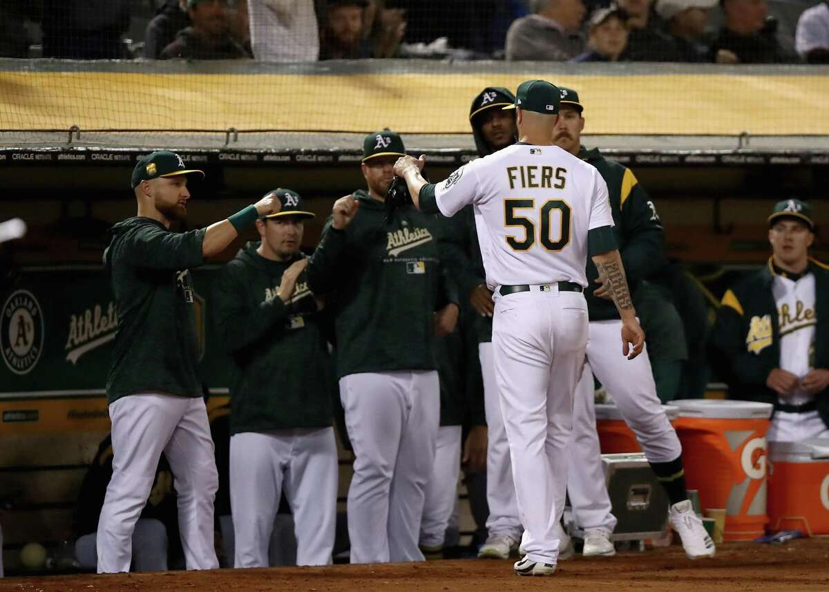 Mike Fiers #50 of the Oakland Athletics is congratulated by teammates after he was taken out of the game in the seventh inning against the New York Yankees at Oakland Alameda Coliseum on September 5, 2018 in Oakland, California.