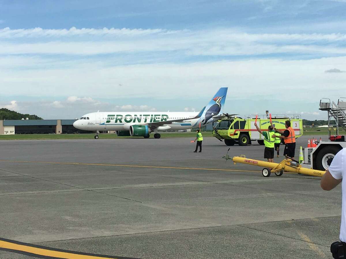 Frontier Airlines' first flight to Albany lands Monday morning at Albany International Airport. Airport fire trucks greeted the plane by spraying a traditional arc of water over the Airbus A321neo as it made its way to the gate.