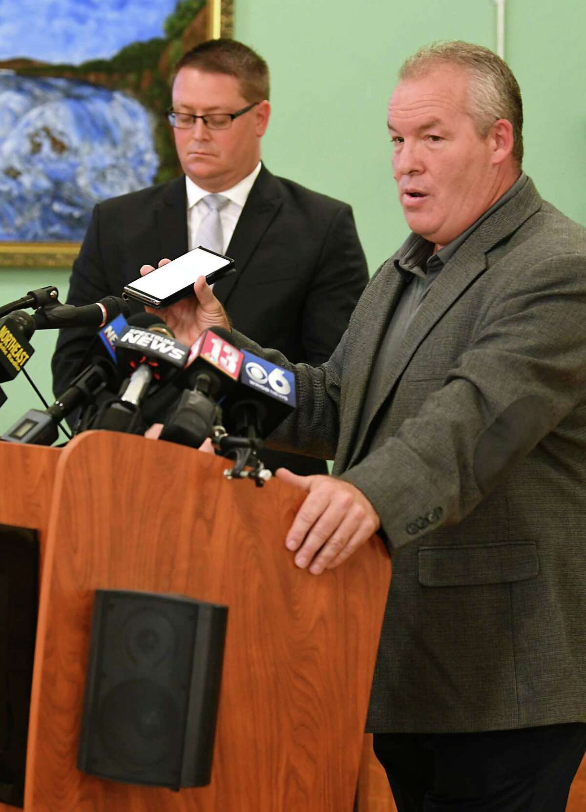 Cohoes Mayor Shawn Morse plays an audio of his upset wife from his cell phone as holds a press conference to speak out about the latest allegations and what's been going on with his family's life at Cohoes City Hall on Monday, Sept. 17, 2018 in Cohoes, N.Y. Morse said he doesn't plan on stepping down from his job. His attorney Joseph Ahearn listens at left. (Lori Van Buren/Times Union)