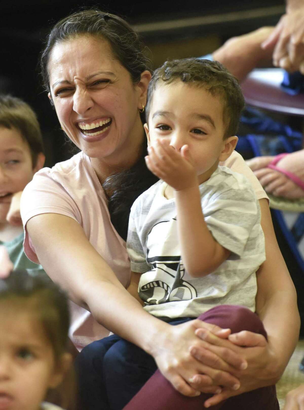 Davina Kahlon and Devin Clermont, 2, of Pemberwick, laugh during magician and juggler Scott Jameson's magic show at the Byram Shubert Library in the Byram section of Greenwich, Conn. Monday, Sept. 18, 2018. Dozens of children and parents marveled in amazement at Jameson's magical and juggling feats. Volunteers joined Jameson in the spotlight to assist with certain tricks in the fun and interactive show.